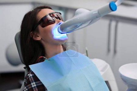 Zahnaufhellung für Frauen. Bleaching der Zähne in Zahnarztpraxis.
