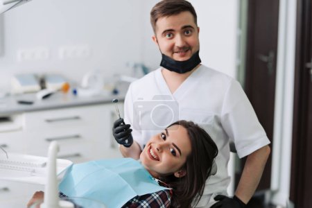 Das Mädchen ist an der Rezeption beim Zahnarzt. Eine zufriedene Kundin beim Zahnarzt lächelt. Zahnaufhellung. Zahnklinik. Behandlung der Zähne in einer modernen Klinik.