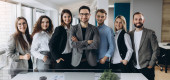 Portrait of a smiling group of diverse corporate colleagues standing in a row together in a bright modern office Poster #653275766