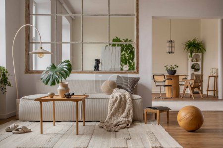 Téléchargez les photos : Interior design of open space interior with modular sofa, big window, stylish lamp, wooden coffee table, round table, rattan chair, pillows, plants and personal accessories. Home decor. Template. - en image libre de droit