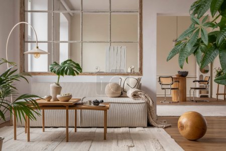 Téléchargez les photos : Open space interior with modular sofa, wooden coffee table, big window, beige rug, braided plaid, pillows, round table, lamp, plants, slippers, ball and personal accessories. Home decor. Template. - en image libre de droit