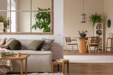 Téléchargez les photos : Interior design of cozy open space with modular sofa, green pillows, braided plaid, wooden coffee table, rattan armchair, round table, plants and personal accessories. Home decor. Template. - en image libre de droit