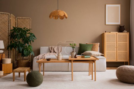 Design intérieur du salon avec canapé modulaire, table basse en bois, buffet en rotin, oreiller vert, lampe, pouf brun, tapis beige, plantes et accessoires personnels. Décor intérieur. Modèle de modèle. 