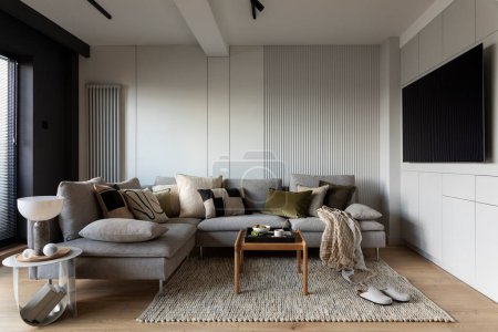 Photo for Creative composition of living room interior with design gray sofa, wooden coffee table, stylish carpet, beige side table, pillows, personal accessories and big tv. Stylish home decor. Template. - Royalty Free Image