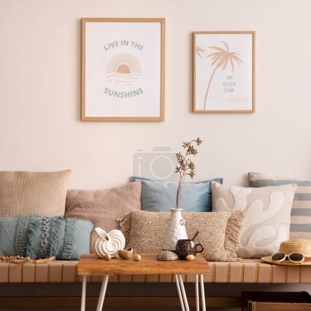 Sunny and bright space of living room with stylish sofa, pillows, coffee table, mock up poster frames, decorations, furnitures and personal accessories. Cozy home decor. Template. Summer vibe