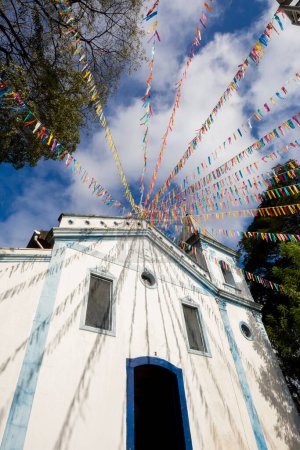 Foto de Iglesia de Nuestra Señora de los Hombres Negros de Penha adornada con coloridos banderines para misa al aire libre y festival folclórico, en el barrio de Penha, ciudad de Sao Paulo, Brasil - Imagen libre de derechos