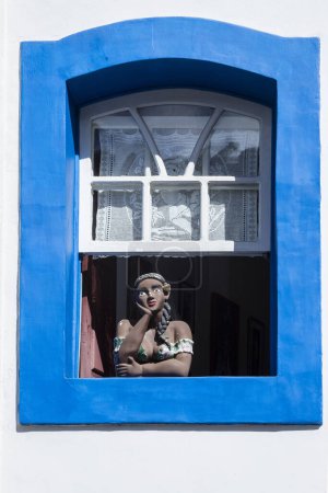 Photo for Namoradeira is a woman looking at street in the window. Brazilian handicraft made with adobe and a colonial traditional sculpture. - Royalty Free Image
