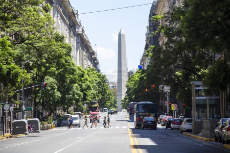 Foto de Buenos Aires, Argentina - 27 de enero de 2024: - Peatones cruzando la calle en la avenida Presidente Roque Saenz Pena con vistas al famoso y turístico Obelisco en la avenida 9 de Julio - Imagen libre de derechos