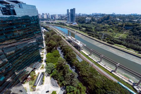 Aerial view of the polluted Pinheiros River next to expressways and modern buildings. Sao Paulo city, Brazil