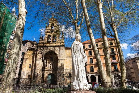Foto de Fachada de la Iglesia de San Vicente Abando, con estatua de Ave María en el jardín, ubicada en la Plaza de San Vicente. Bilbao, País Vasco - Imagen libre de derechos