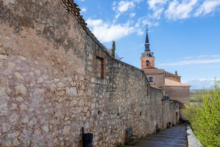 Vista del exterior de las murallas de la ciudad de Lerma, con una torre de la iglesia en el fondo. España