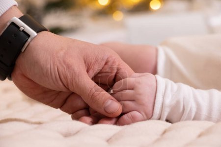 Photo for Dad's hand holds the hand of a newborn close-up, love and family, hand of a newborn, children - Royalty Free Image