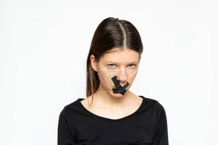 Foto de Chica con la boca sellada sobre un fondo aislado, guardar silencio y no decir nada, secreto - Imagen libre de derechos