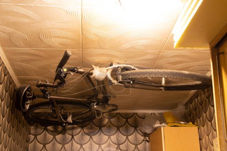 Bicycle mounted on the ceiling in a small residential apartment with limited space, bicycle storage at home, idea