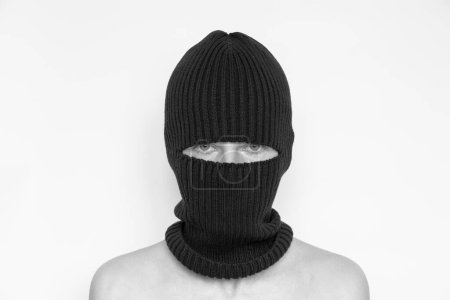 Foto de Sombrero de pasamontañas en una chica sobre un fondo blanco, la cara de un ladrón en sombreros con una ranura para verbos - Imagen libre de derechos