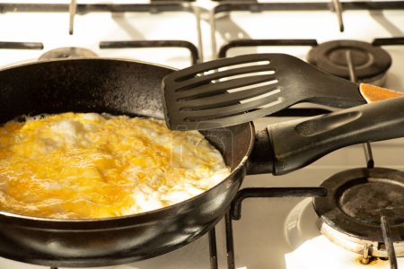Omelette in a frying pan on a gas stove at home in the kitchen ,cook food