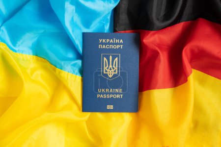 Flag of Ukraine and Germany in the middle lies Foreign biometric passport of a Ukrainian, migrate