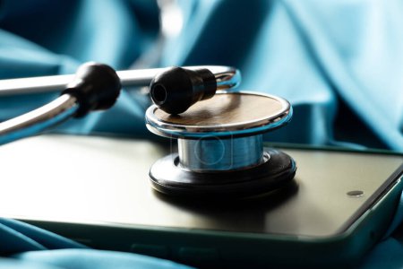 A stethoscope lies on a smartphone on a blue background, online doctor, doctor call