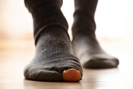Les pieds des femmes en chaussettes holey se tiennent sur le sol de la maison, la pauvreté, les pieds