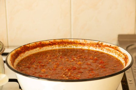 Homemade spicy adjika to cook in a saucepan at home in the kitchen, spicy adjika to cook, sauce