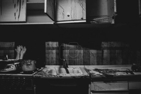 Photo for Horror room, kitchen in splashes of blood and hands in a pan on the stove in the kitchen in the dark, black and white photo, room of a maniac and killer - Royalty Free Image