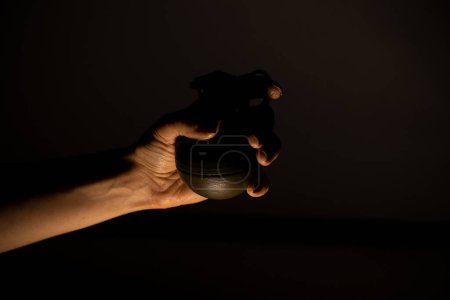 Foto de Una granada de mano en las manos de una chica en la oscuridad, una granada de combate - Imagen libre de derechos