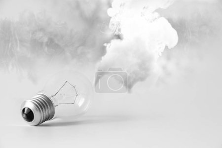 Incandescent light bulb and smoke on a white background, light and electricity