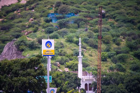 Photo for Jaipur, Rajasthan India - Circa 2022: Aravalli range in jaipur rajasthan with small hills mountains covered in green trees under monsoon clouds with bharat petroleum fuel station and temple - Royalty Free Image