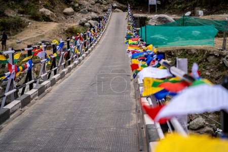 Foto de Banderas de oración sagradas religiosas multicolores colocadas a ambos lados del puente que se mueven en el viento mostrando un conjuro de oración bhuddista común en las estaciones de las colinas en Himachal Pradesh India - Imagen libre de derechos