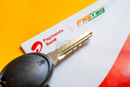 Foto de Delhi, India - 27 de marzo de 2024: Primer plano de Airtel Payment bank Fijación y llave del coche colocada en la mesa amarilla que muestra el pago RFID por NHAI - Imagen libre de derechos