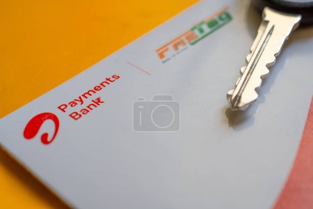 Foto de Delhi, India - 27 de marzo de 2024: Primer plano de Airtel Payment bank Fijación y llave del coche colocada en la mesa amarilla que muestra el pago RFID por NHAI - Imagen libre de derechos