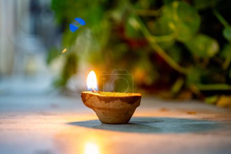 Lámpara diya orgánica hecha de fibra de coco orgánica llena de aceite y encendida para proporcionar luz y como ofrenda a los dioses hindúes en el festival de diwali India