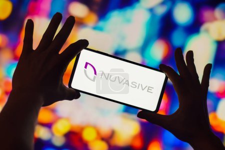 Foto de 28 de noviembre de 2022, Brasil. En esta ilustración fotográfica, el logotipo de NuVasive se muestra en la pantalla de un teléfono inteligente - Imagen libre de derechos