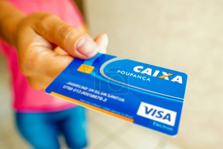 Foto de January 6, 2023, Brazil. In this photo illustration, a woman shows the Citizen Card, from Caixa Econmica Federal. Document was created by the Brazilian federal government in order to unify the functional accounts to which workers are entitled. - Imagen libre de derechos