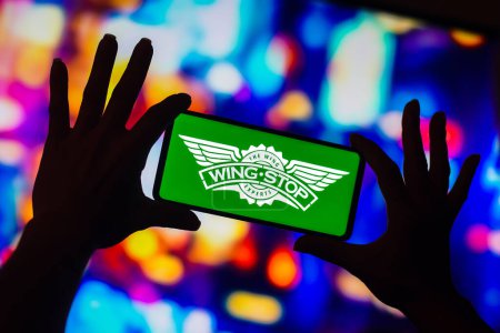 Photo for January 16, 2023, Brazil. In this photo illustration, the Wingstop Inc. logo is displayed on a smartphone screen - Royalty Free Image