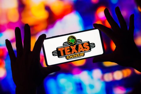 Téléchargez les photos : January 16, 2023, Brazil. In this photo illustration, the Texas Roadhouse logo is displayed on a smartphone screen - en image libre de droit