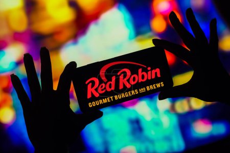 Téléchargez les photos : January 16, 2023, Brazil. In this photo illustration, the Red Robin Gourmet Burgers logo is displayed on a smartphone screen - en image libre de droit