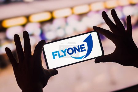 Téléchargez les photos : January 19, 2023, Brazil. In this photo illustration, the FlyOne logo is displayed on a smartphone screen. It is a privately owned, low-cost airline headquartered in Chiinu, Moldova. - en image libre de droit