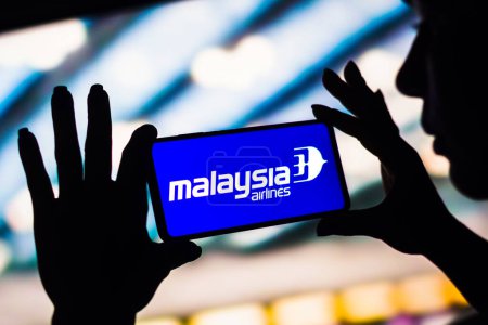Foto de 4 de febrero de 2023, Brasil. En esta ilustración fotográfica, el logotipo de Malaysia Airlines se muestra en la pantalla de un teléfono inteligente - Imagen libre de derechos