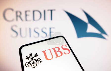 Photo for March 20, 2023, Brazil. In this photo illustration the UBS logo seen displayed on a smartphone and Credit Suisse logo on the background - Royalty Free Image