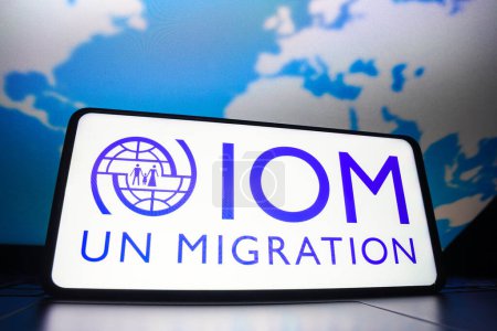 Téléchargez les photos : 23 mars 2023, Brésil. Dans cette illustration photo, le logo de l'Organisation internationale pour les migrations (OIM) affiché sur un écran de smartphone - en image libre de droit