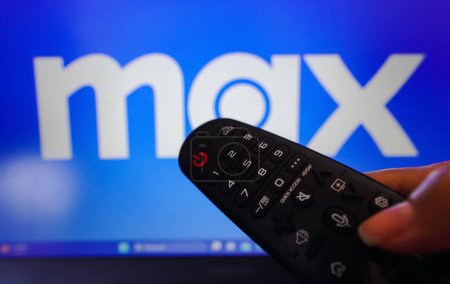 Photo for April 13, 2023, Brazil. In this photo illustration, a hand holding a TV remote control in front of a Max logo on a TV screen - Royalty Free Image