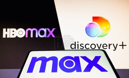 Foto de 13 de abril de 2023, Brasil. En esta ilustración fotográfica, el logotipo de Max se muestra en un teléfono inteligente y el logotipo de HBO Max y Discovery en el fondo - Imagen libre de derechos