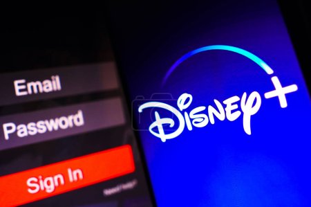 Photo for May 2, 2023, Brazil. In this photo illustration, the Disney Plus logo is displayed on a smartphone screen, next to a login screen, with email, password and sign in - Royalty Free Image
