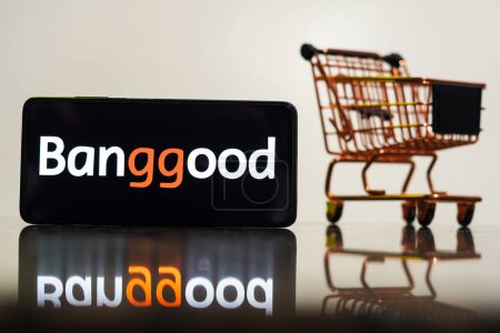 Foto de 8 de mayo de 2023, Brasil. En esta ilustración fotográfica, el logotipo de Banggood se muestra en un teléfono inteligente junto con un carrito de compras - Imagen libre de derechos