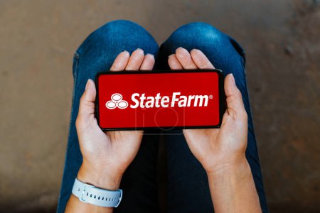 Foto de 7 de junio de 2023, Brasil. En esta ilustración fotográfica, el logotipo de State Farm Insurance se muestra en la pantalla de un teléfono inteligente - Imagen libre de derechos