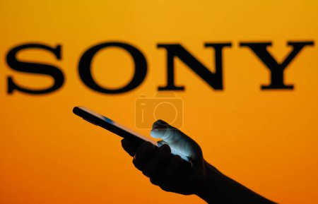 Téléchargez les photos : 13 juin 2023, Brésil. Dans cette illustration photo le logo Sony vu en arrière-plan d'une femme silhouette tenant un téléphone portable - en image libre de droit