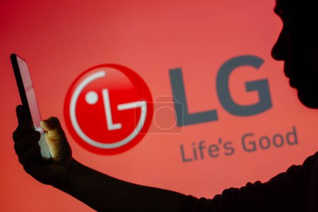 Téléchargez les photos : 13 juin 2023, Brésil. Dans cette illustration photo, le logo LG est vu à l'arrière-plan d'une femme silhouette tenant un téléphone portable - en image libre de droit