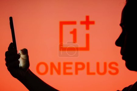 Téléchargez les photos : 13 juin 2023, Brésil. Dans cette illustration photo, le logo OnePlus est vu à l'arrière-plan d'une femme en silhouette tenant un téléphone portable - en image libre de droit