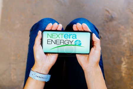 Photo for July 2, 2023, Brazil. In this photo illustration, the NextEra Energy logo is displayed on a smartphone screen - Royalty Free Image